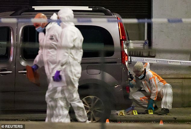 Forensic investigators at the scene in Brussels were two people were shot dead by the gunman